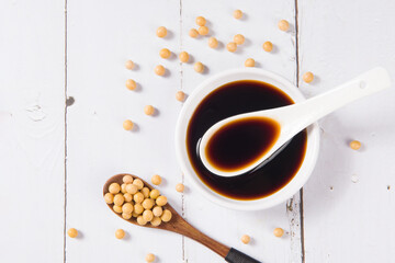 soy sauce and soybean on white wooden background