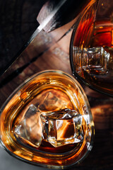 a cut of a tree, cut with a hatchet, there are two glasses of whiskey and ice on it. rest concept after a hard day at work. whiskey and wood