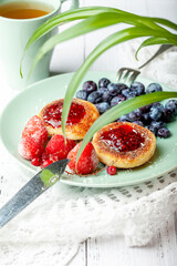 Cheesecakes with raspberry jam, berries, served with a cup of tea, cheesecakes
