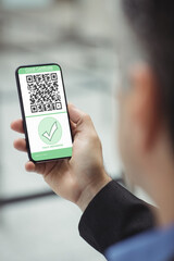 Man holding smartphone with covid 19 vaccine passport