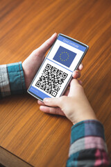 Man holding smartphone with covid 19 vaccine passport