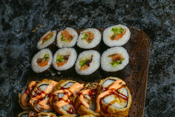 Traditional delicious fresh sushi roll set on a black background