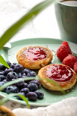 Cheesecakes with raspberry jam, berries, served with a cup of tea, cheesecakes
