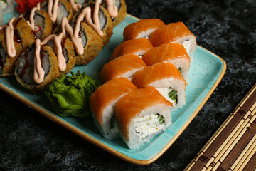 Traditional delicious fresh sushi roll set on a black background