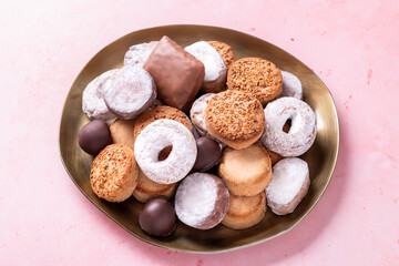 Holiday delicacies polvorones and mantecados in golden plate on pink table overhead