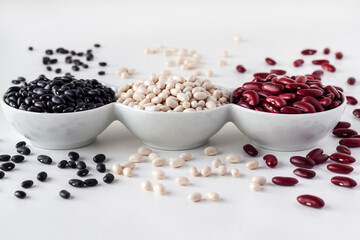 Assortment of beans in a white bowl on white background