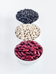 Assortment of beans in a white bowl on white background