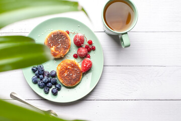 Cheesecakes with raspberry jam, berries, served with a cup of tea, cheesecakes
