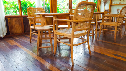 Set of brown table and chairs with weaved backrests on the brown wooden floor