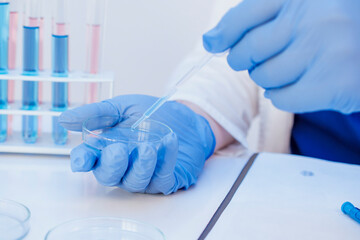 Medical insurance during a pandemic. Close up medical doctor in uniform and gloves puts vaccine antiretroviral coronavirus covid 19 on a test tubes flask with virus