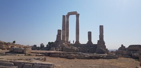 La célèbre citadelle de la ville d'Amman, en Jordanie, tas de ruines dans une zone desertique et urbaine, cité à moitié détruite, colonnes style romaines et égyptiennes, de marbre et rayons de Soleil 