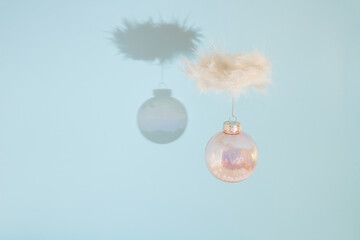 Christmas decoration bauble. Creative idea made with white feathers on blue background.