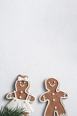 Decorated Christmas gingerbread cookies with decorations on white table background.