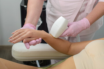 Laser hair removal on ladies hand. woman in beige lingerie