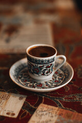 A tinny cup of traditional black strong Turkish coffee. Traditional drinks, coffee concepts. Vertical