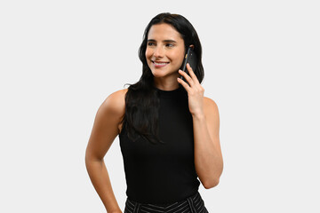 Naklejka premium Corporate woman using cellphone wearing sleeveless casual top. Good looking fair skin brunette woman looking away the front camera