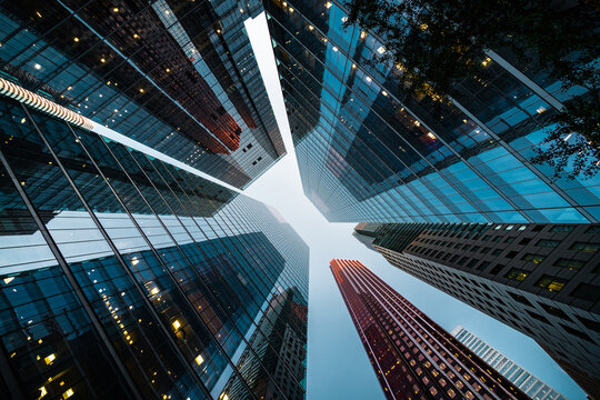 Looking up at high rise office building architecture against blue sky in the financial district of a modern metropolis, business and finance concept.	