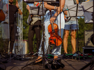 Fototapeta na wymiar Female violinist standing near music stand outdoors