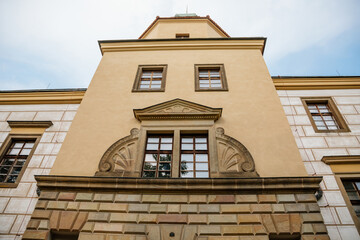 Obraz premium Castolovice, Eastern Bohemia, Czech Republic, 11 September 2021: renaissance castle with tower at sunny day, courtyard with arcades and geometric flower beds, murals and sgraffito plaster on walls
