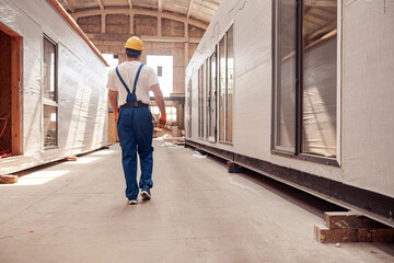 Male worker walking down the building under construction