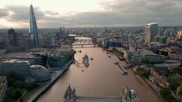 Aerial view to the iconic Tower Bridge and skyline of London, UK, during sunset time. Traffic going across the bridge.