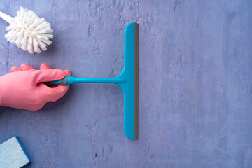 Hand in pink glove holding window cleaning brush