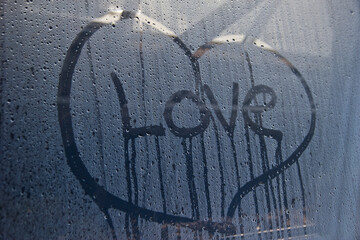 the inscription love on the misted glass