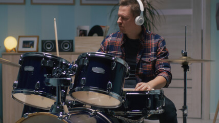 Adult man playing drums at home