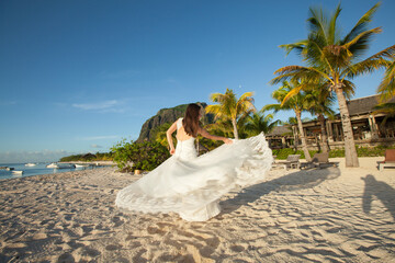 Fototapeta na wymiar Beautiful bride in white dress on the beach
