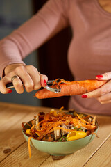 Women scraps peels carrots vegetable peeling, throws in compost bucket, organic composting