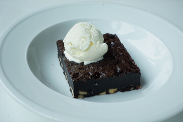 slice of brownie and ice cream on plate on table 