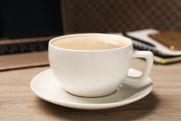 Coffee Break at workplace. Cup of hot drink on wooden table