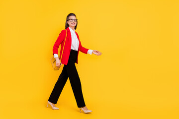 Full body profile photo of agent old woman go wear cardigan trousers bag eyewear high heels isolated on yellow background