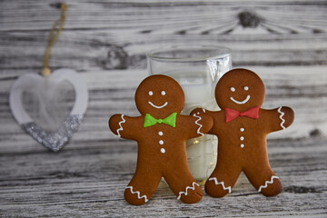 Milk with gingerbread cookies for Santa. Handmade fresh cookies and glass with milk on the vintage wooden table. Christmas traditions. Aesthetic atmosphere and festive Christmas background. Copy space