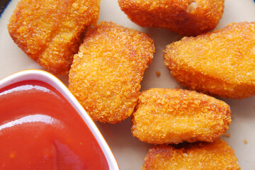 close up of chicken nugget and sauce on table 