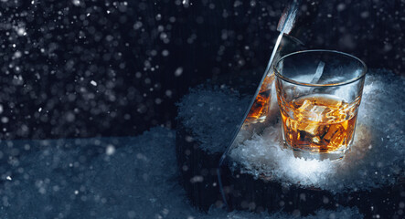 a glass of whiskey in the snow. concept of a warming drink on a cold winter evening.