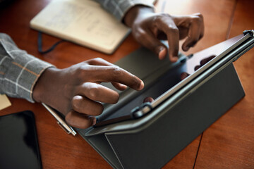 African businessman working on a digital tablet at home