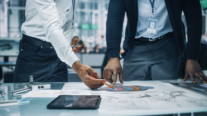 Close Up of Two Automotive Engineers Working in Office at Car Factory. Industrial Designer Shows Conceptual Electric Engine Parts to Colleague, Discussing Work in Technological Laboratory.