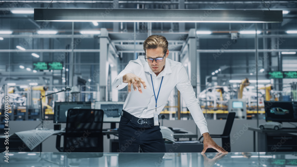 Poster Confident Engineer in White Shirt Making Gestures of Moving Invisible Object in Virtual Reality in an Office at Car Assembly Plant. Industrial Specialist Working in Technological Development Facility.
