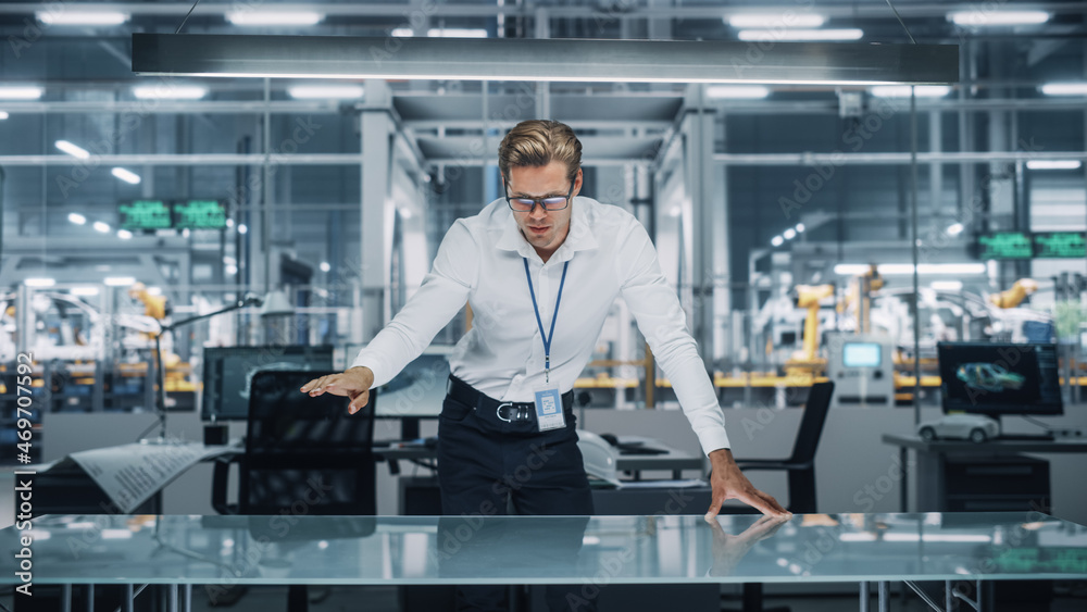 Poster Confident Engineer in White Shirt Making Gestures of Moving Invisible Object in Virtual Reality in an Office at Car Assembly Plant. Industrial Specialist Working in Technological Development Facility.