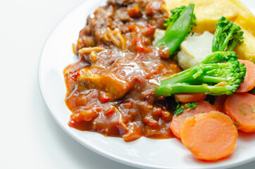 Pulled pork in barbecue style sauce with barbecues style beans with spiced chips and fresh vegetables