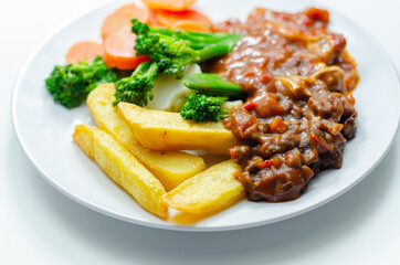 Pulled pork in barbecue style sauce with barbecues style beans with spiced chips and fresh vegetables