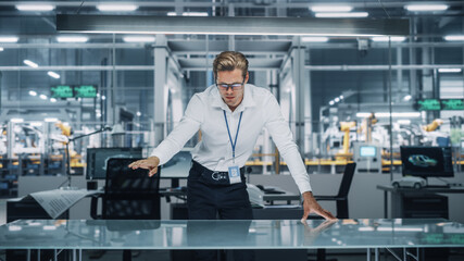Confident Engineer in White Shirt Making Gestures of Moving Invisible Object in Virtual Reality in an Office at Car Assembly Plant. Industrial Specialist Working in Technological Development Facility.