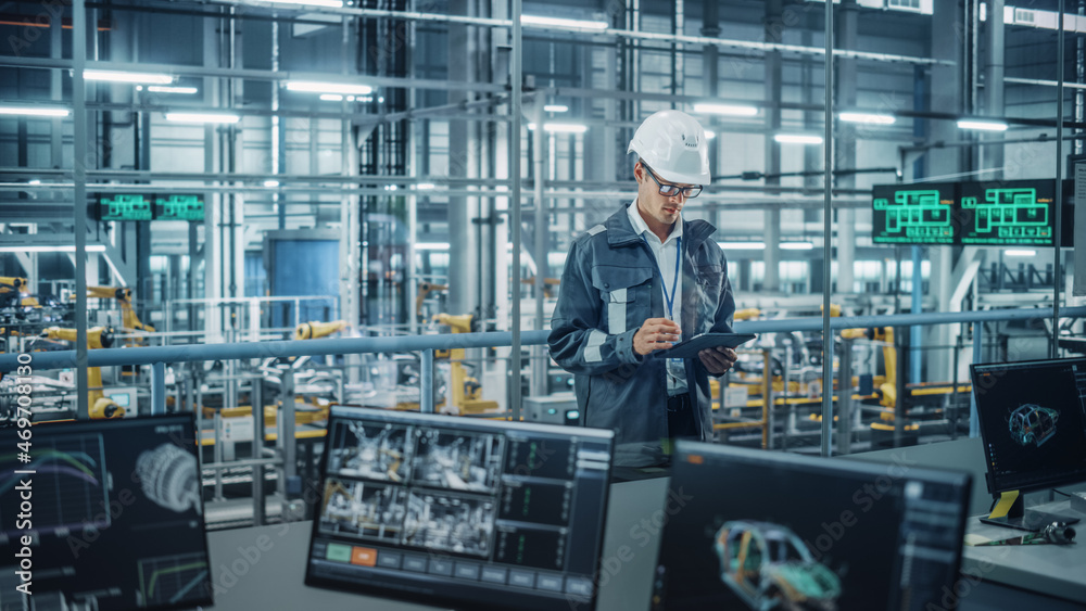 Aufkleber handsome engineer in uniform and hard hat using tablet computer at a car assembly plant. industrial 