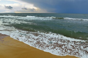 Iridescent ocean in cloudy sunny weather.