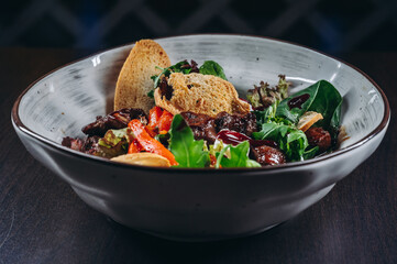 Warm salad mix with chicken liver and crouton. Restaurant food.