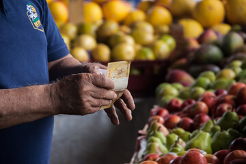 Dinheiro deixado no stand de laranjas, para pagamento de alguma compra.