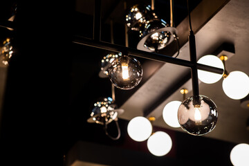 Design lamps in the form of glass balls on black rails and frames. 