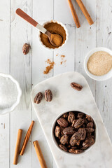 Top down view of a bowl of candied pecans surrounded by ingredients to make them