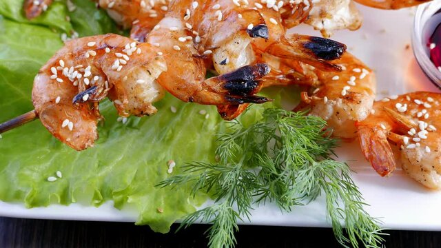 Shrimp kebabs with lemon and sauce - seafood on a white plate